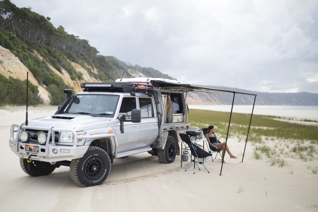 A woman sitting on front of a campervan on Rainbow Beach